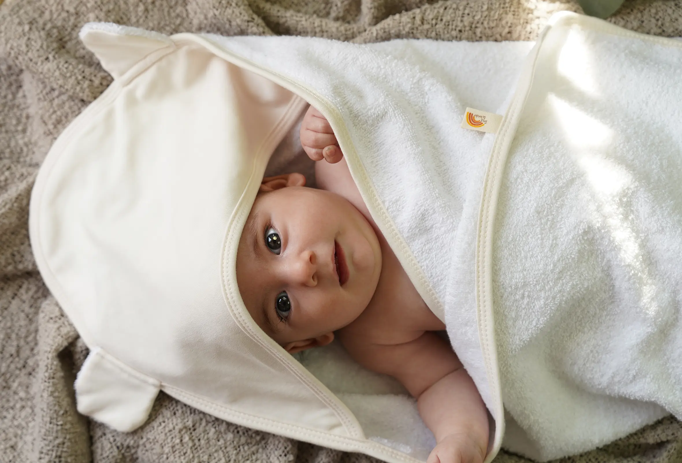 Kapuzenhandtuch in der Farbe Natur mit einem Neugeborenen - aus weicher Bio-Baumwolle