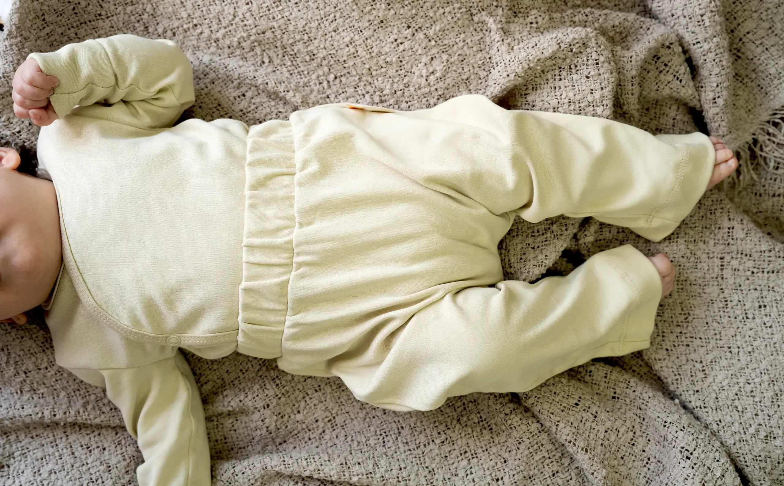 Schlupfhose für Neugeborene in der Farbe Creme-Gold, aus weicher und nachhaltiger Bio-Baumwolle. Neugeborenes mit Schlupfhose in der Farbe Creme-Gold aus Bio-Baumwolle